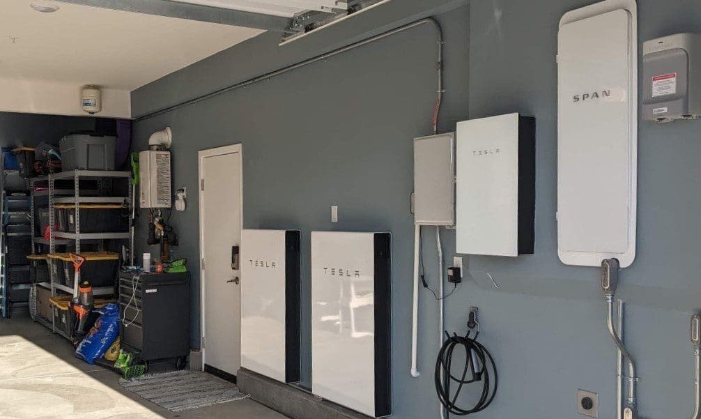 SPAN panel and Tesla-branded equipment mounted along a garage wall.