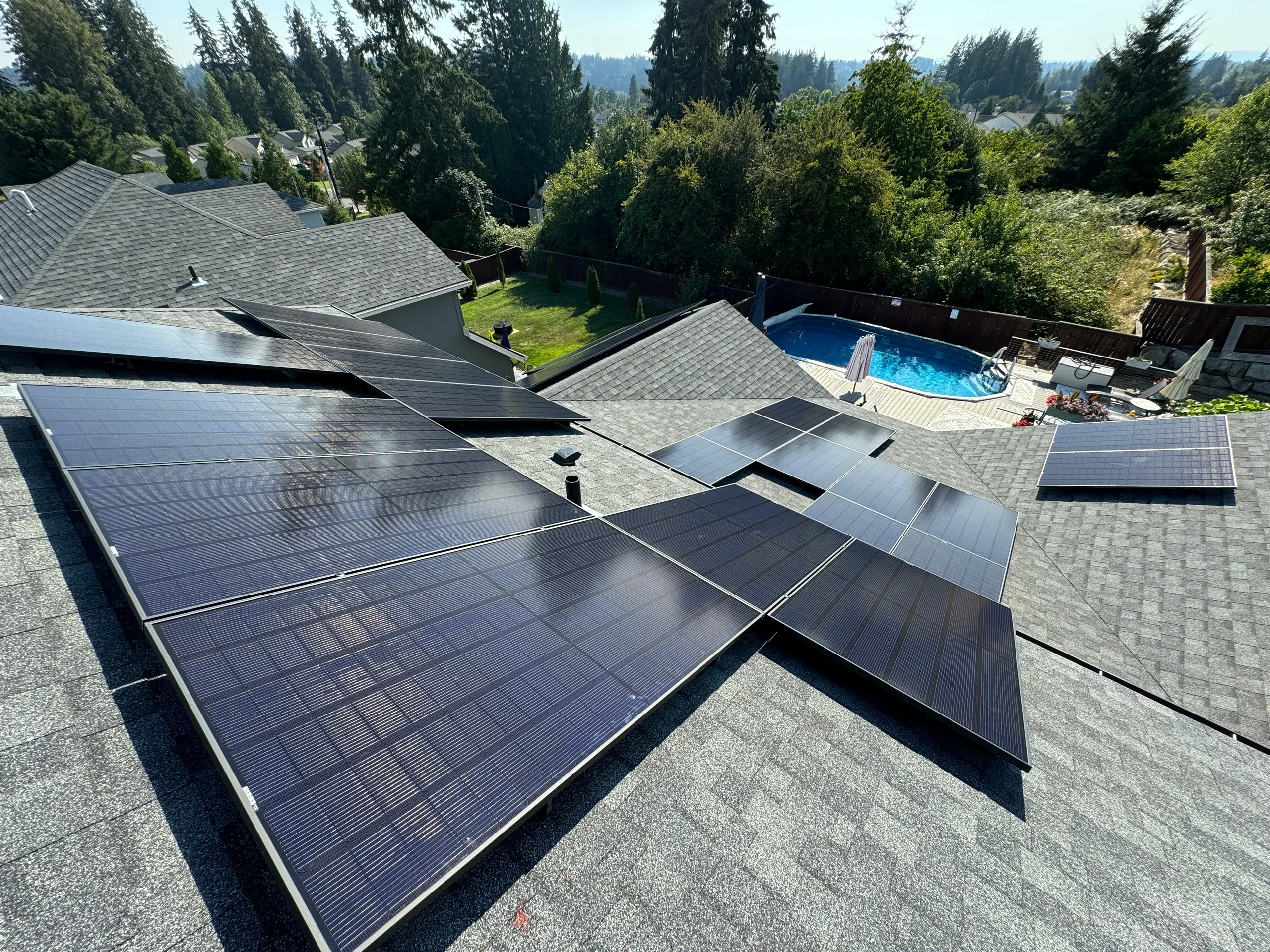 Solar panels mounted across several sections of a shingled residential roof.