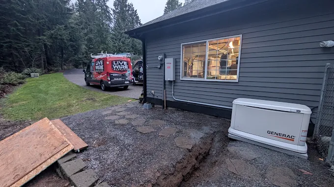 A Generac standby generator outside a home with a Live Wire Electric van in the driveway